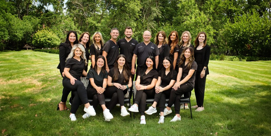 Hickman Family Dental team in black scrubs posing outdoors, showcasing a welcoming and friendly atmosphere for comprehensive family dental care.